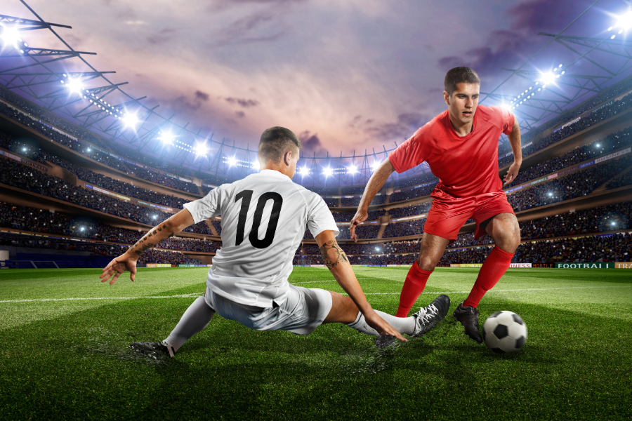 2 people playing football in a football court