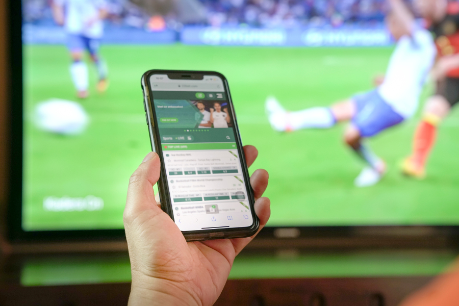 a person betting using the phone on a football match
