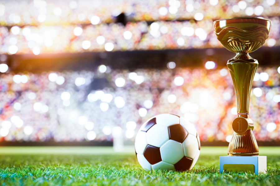 a football and the winning cup on the football ground