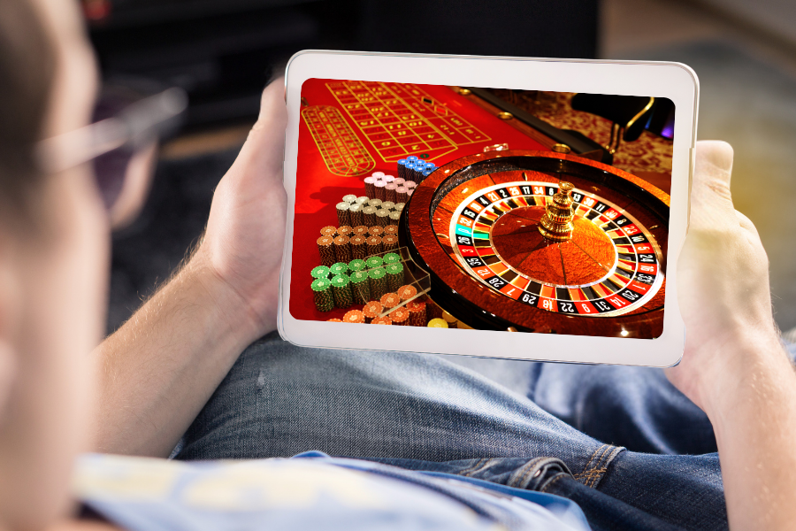 a man is playing online roulette sitting on a sofa
